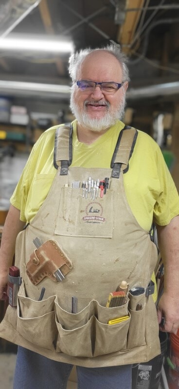 Woodworker wearing a Katz-Moses apron filled with layout tools and woodworking gear