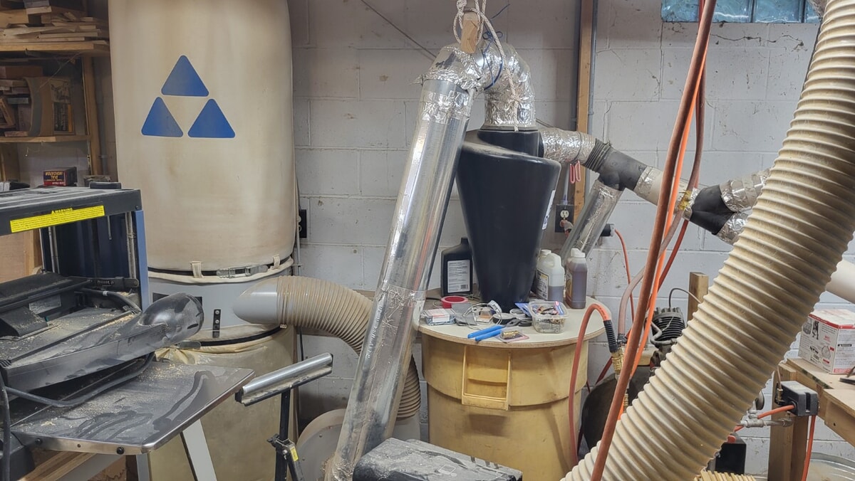 Woodshop dust collector system with cyclone separator and piping connected to stationary machines to control dust and improve air safety