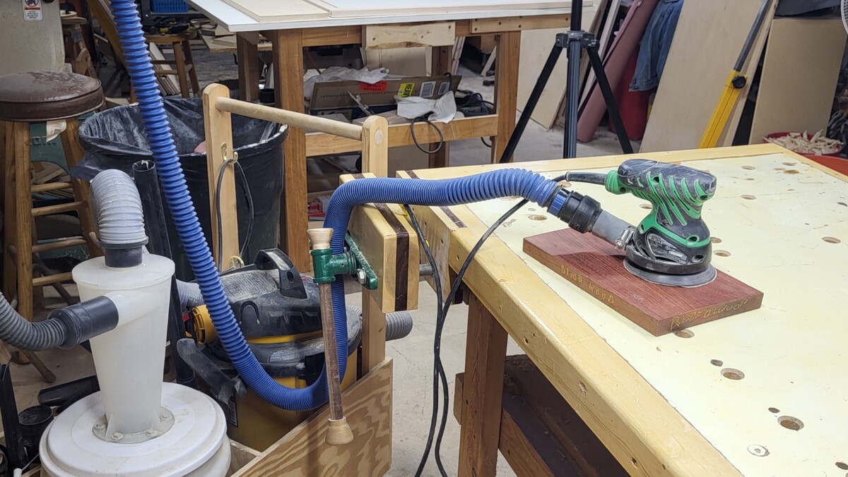 Random orbital sander hooked up to a shop vacuum and cyclone separator for dust control, reducing airborne dust while sanding in the woodshop
