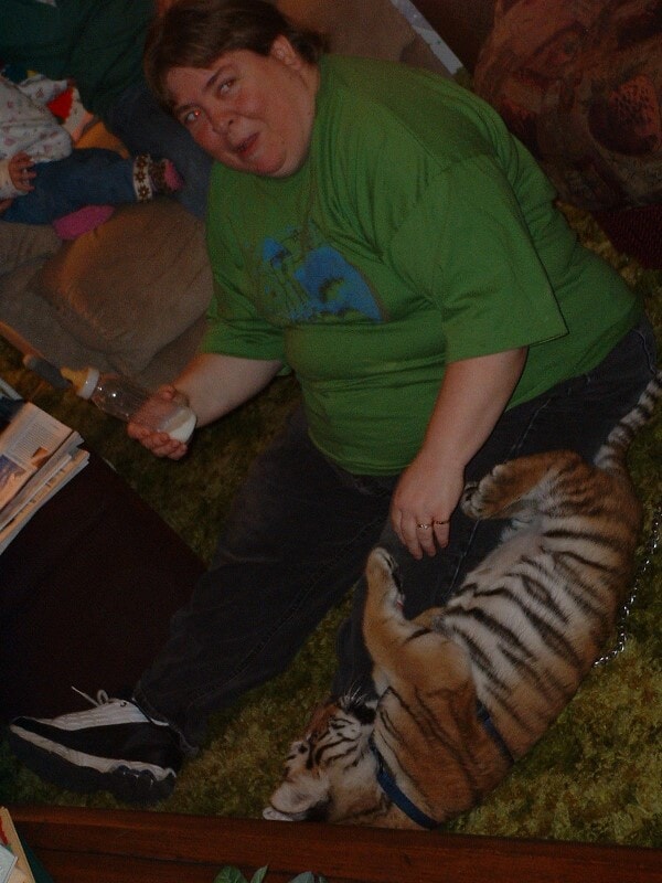 Cindy smiling brightly as she gently holds and plays with a tiger cub at a friend’s house in 2003. Her excitement and joy are unmistakable as she cradles the big kitten in her arms, reflecting her lifelong love of animals.