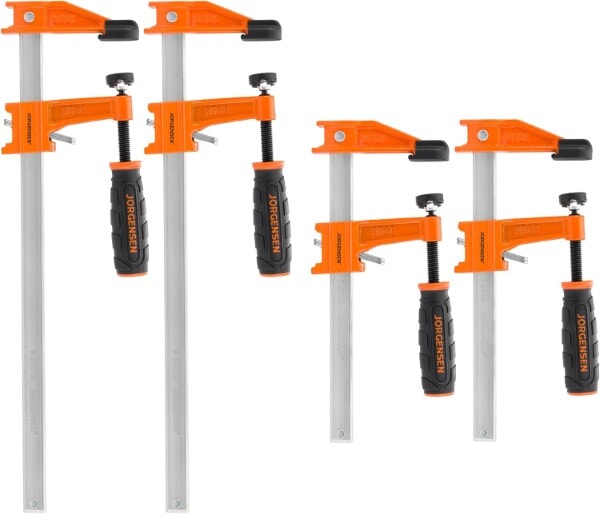 Set of Jorgensen steel bar clamps with orange jaws and black ergonomic handles arranged in a group.